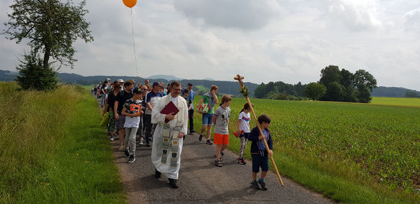 Unterwegsgottesdienst mit Stadtpfarrer Stefan Buß. Das Pilgerkreuz geht voran.